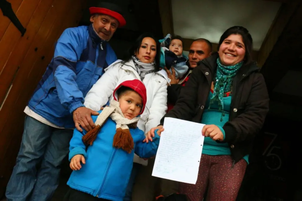 Los padres del CDI Pequeños Corazones con el documento -compromiso firmado por los funcionarios.