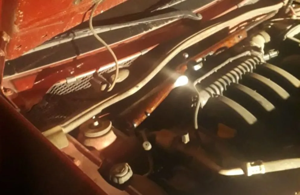 Trasladaban un arma de fuego en el motor de una camioneta