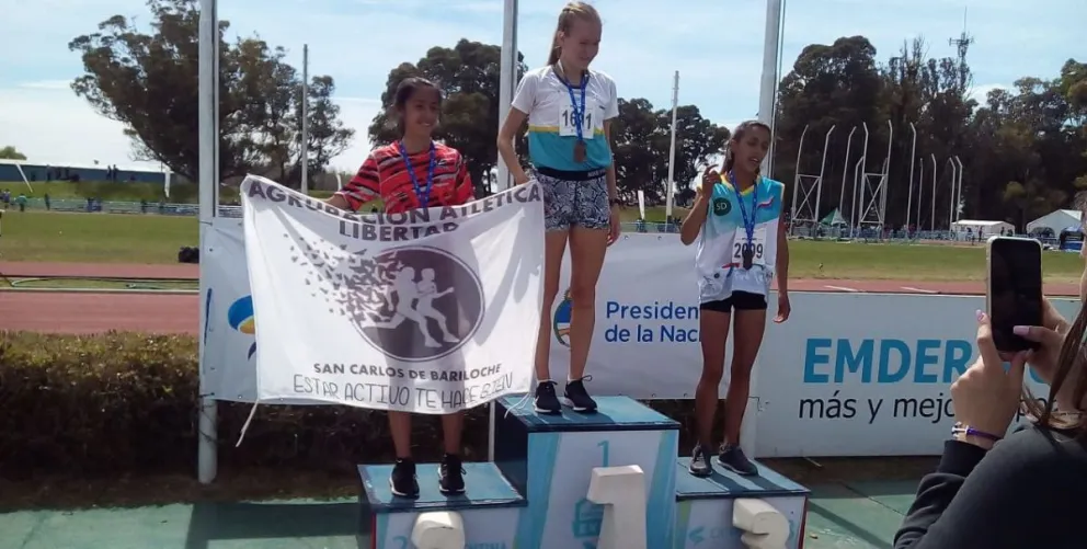 A la izquierda, Rocío con la bandera de la Agrupación Atlética Libertad.